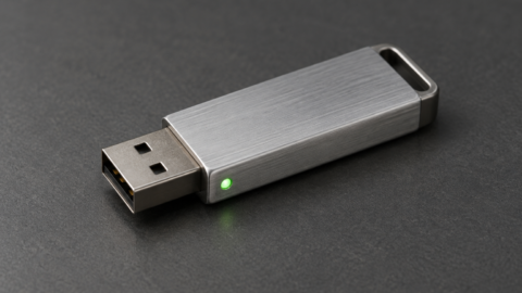 Clé USB métallique avec un voyant vert allumé.