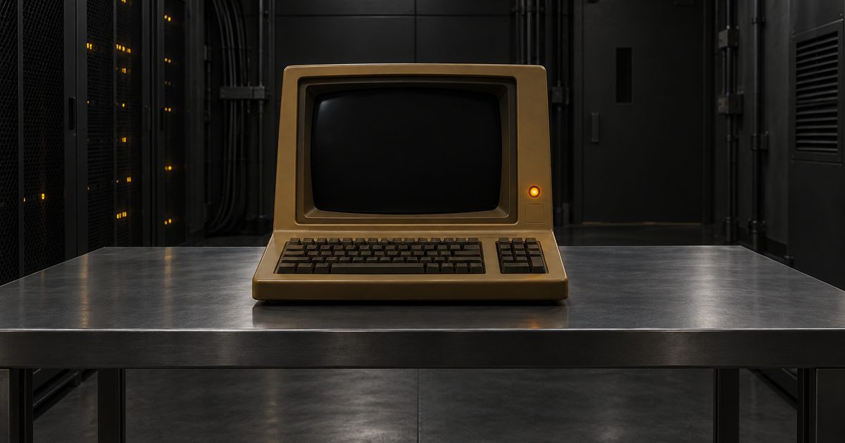 Ancien ordinateur portable beige posé sur une table métallique devant des serveurs.